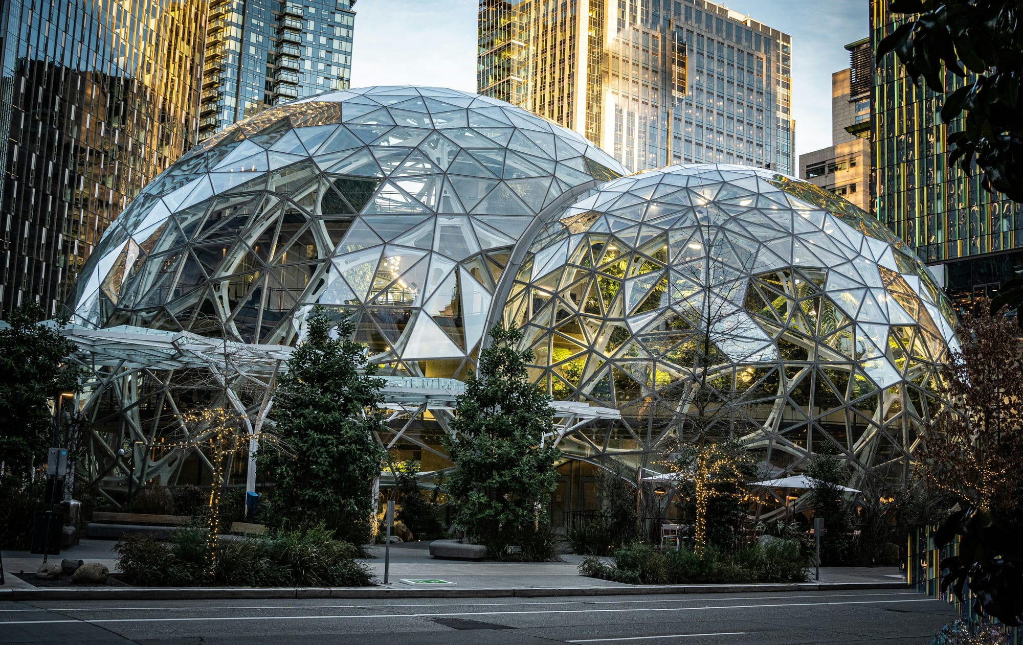 Glass geodesic domes at Amazon’s Seattle headquarters, known as the Spheres, surrounded by modern office buildings and trees.