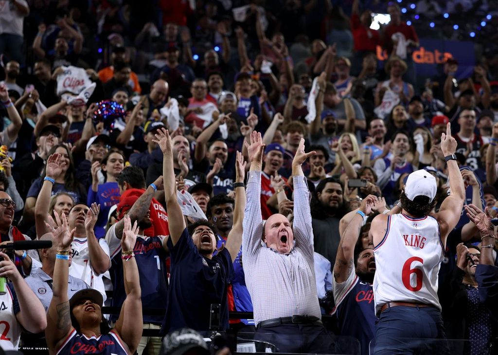 Steve Ballmer enthusiastically doing the wave from his seat at Intuit Dome surrounded by like minded LA Clippers' fans.