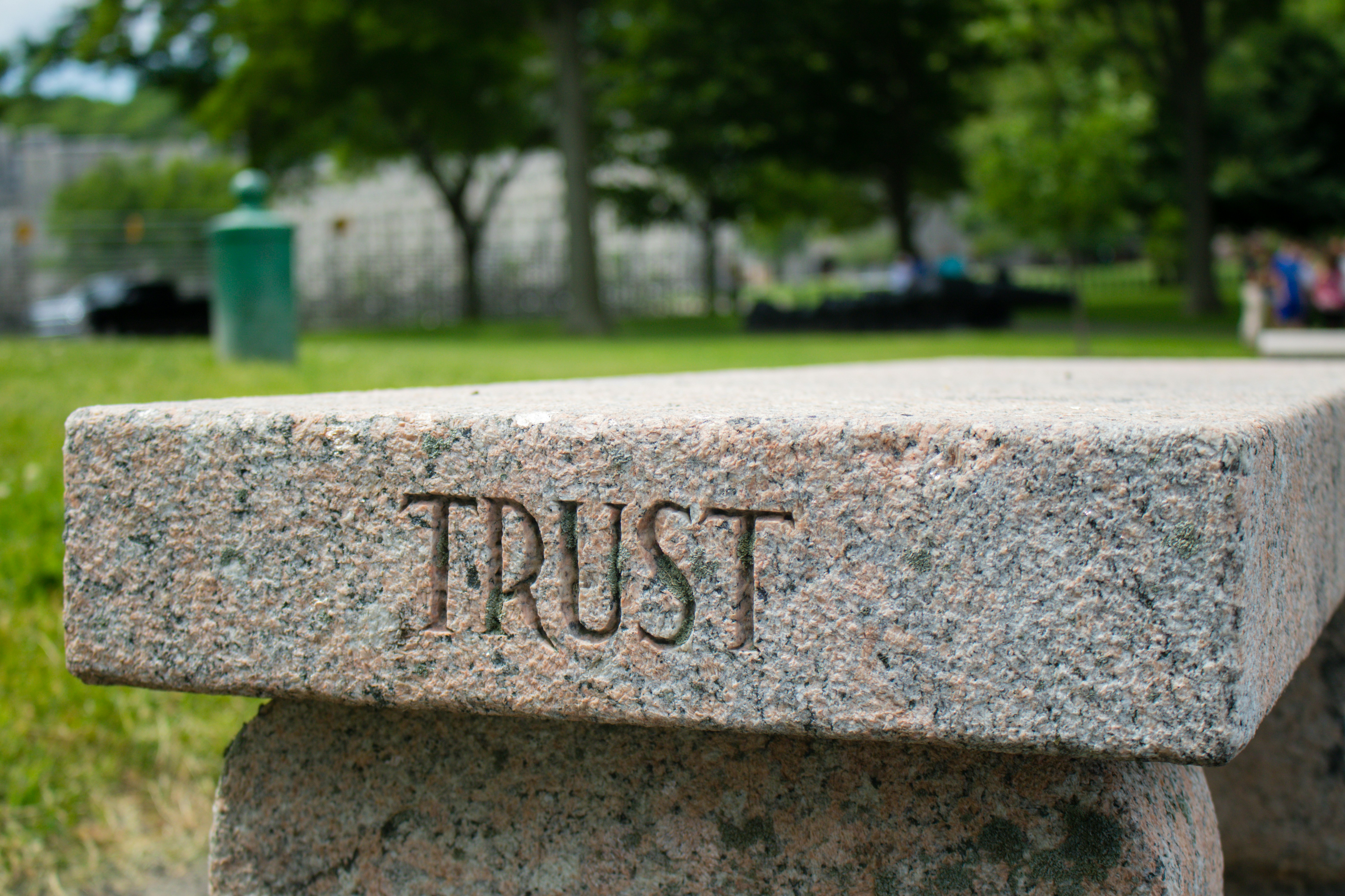 Stone bench with the word 'TRUST' etched in the side.