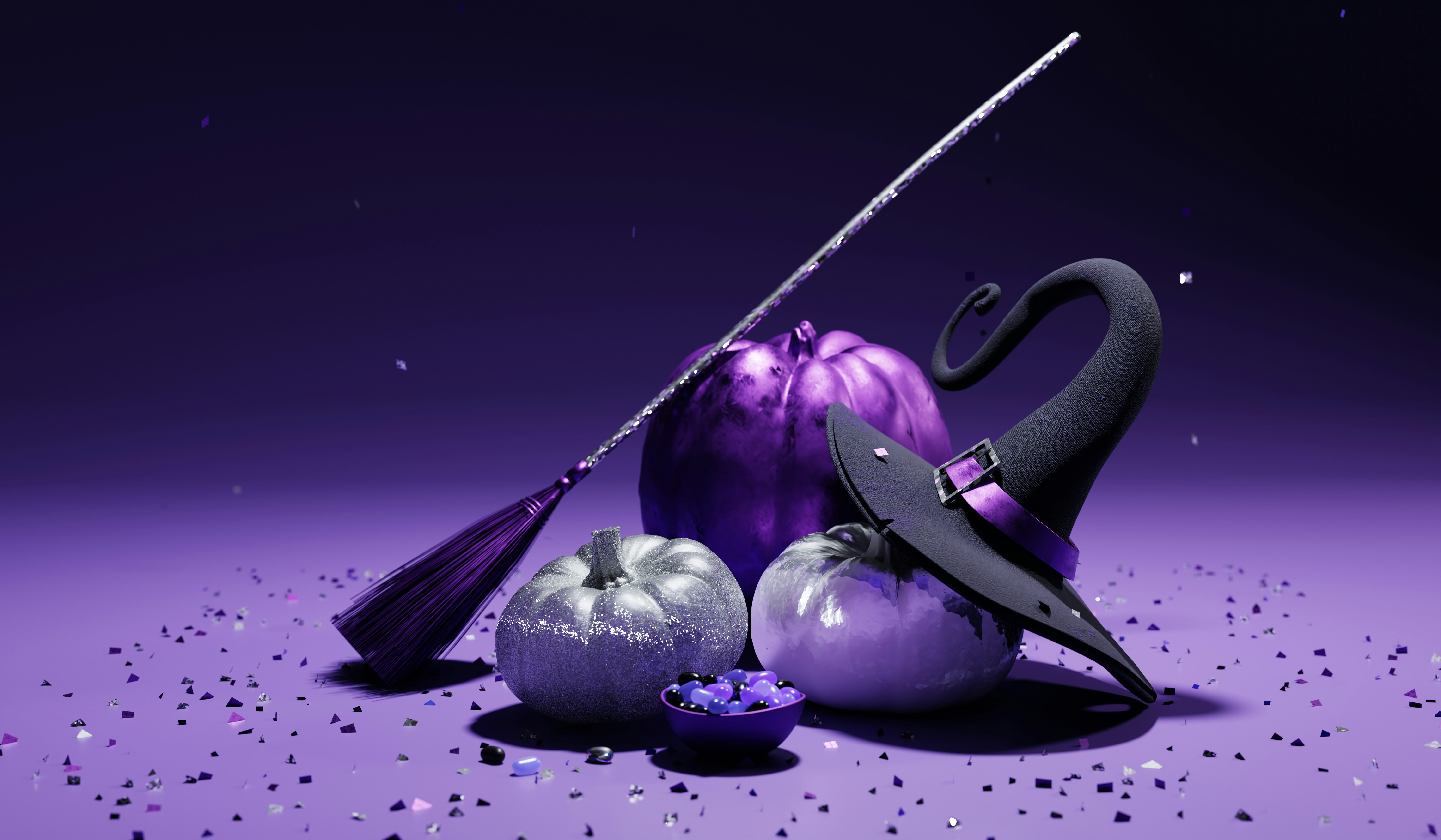 A Halloween-themed still life featuring metallic purple and silver pumpkins, a glittering broom, a witch’s hat with a purple band, and scattered confetti on a purple surface.