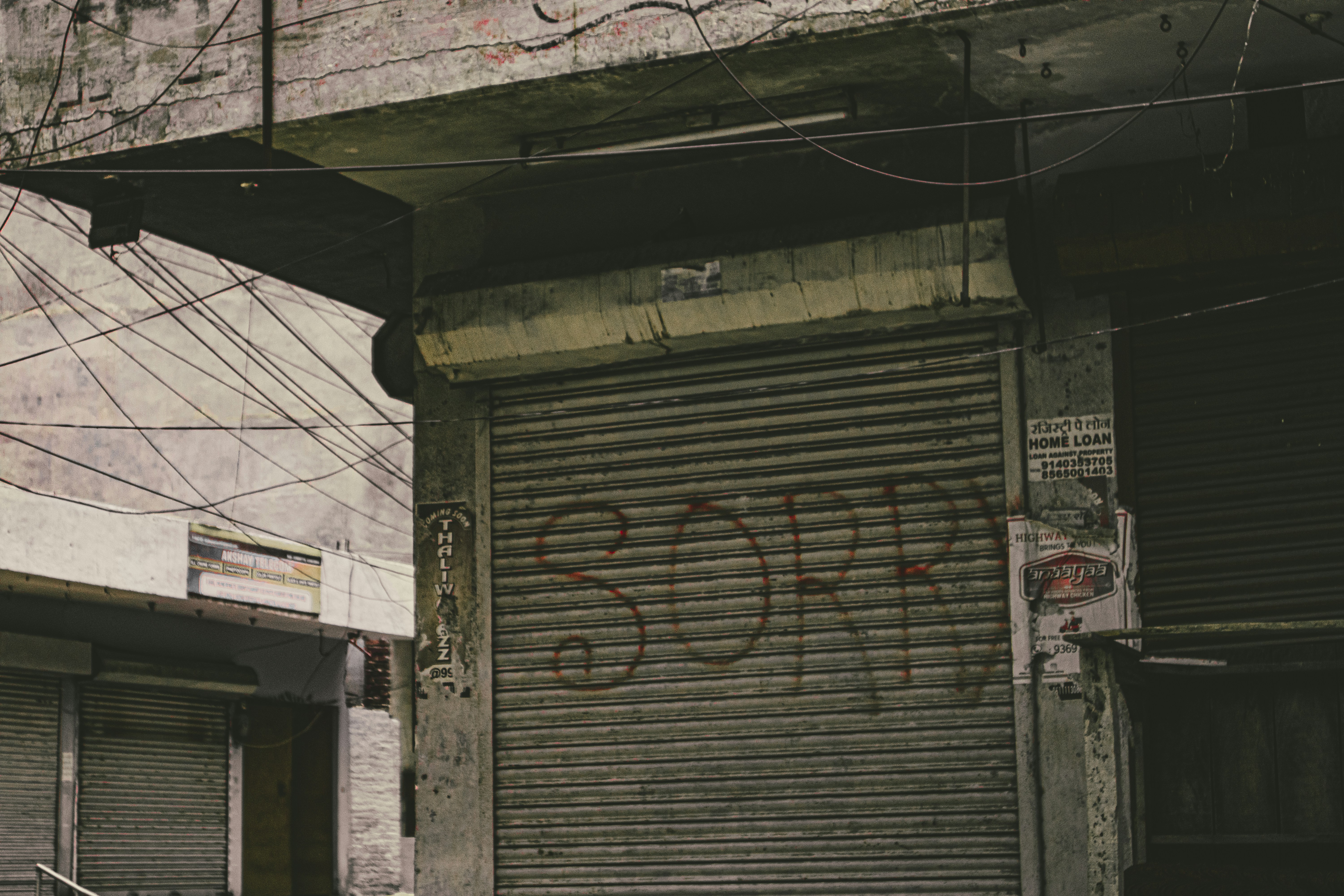 Corrugated aluminum garage door with the grafitti  "SORRY" painted on the door.
