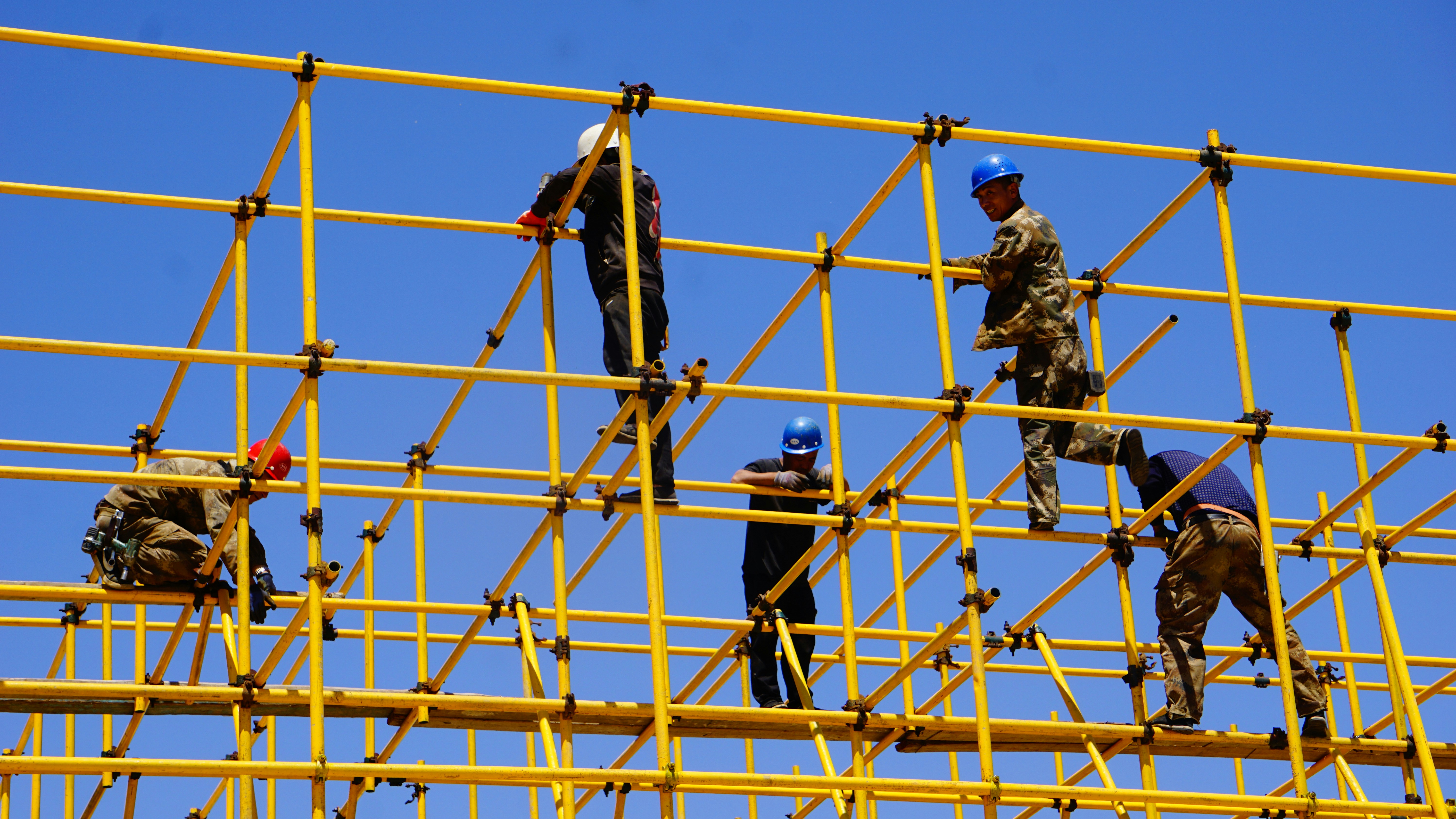 People building yellow scaffolding