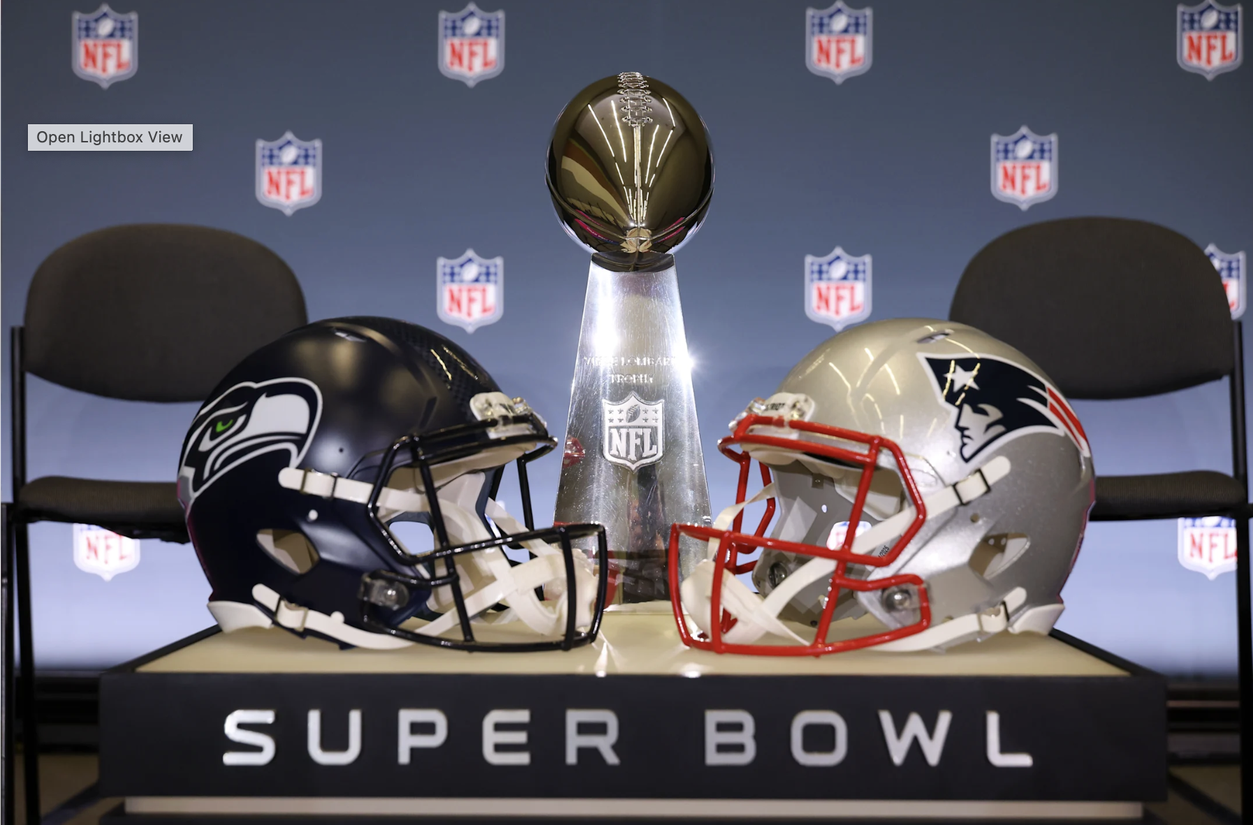 Lombardi Trophy flanked by Seattle Seahawks and New England Patriots helmets ahead of the Super Bowl.