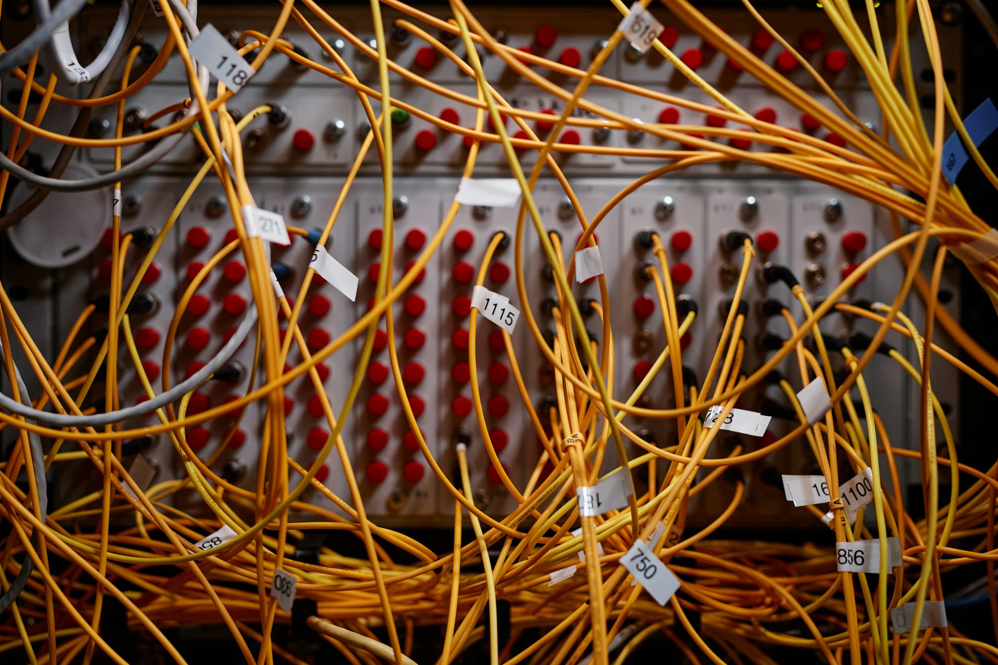Close-up of a dense bundle of yellow network cables connected to a patch panel.