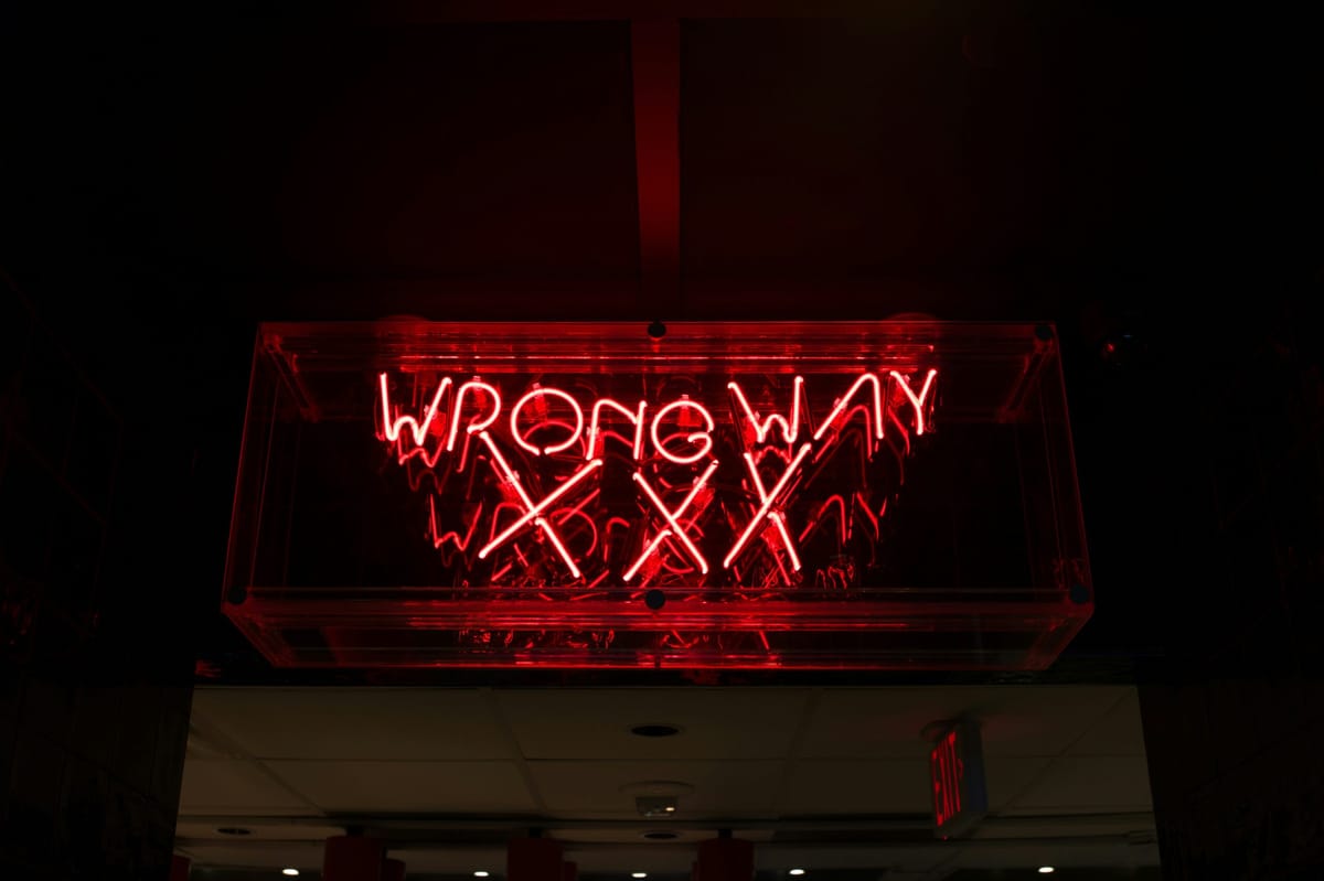 Pink neon sign that says Wrong Way xxx