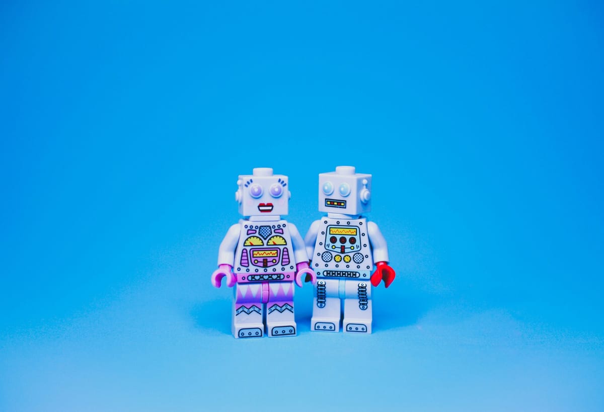 Two toy robots holding hands.