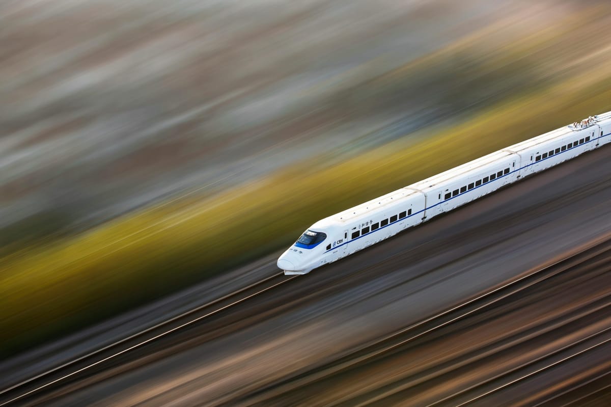 Blurred high speed train racing along the tracks.