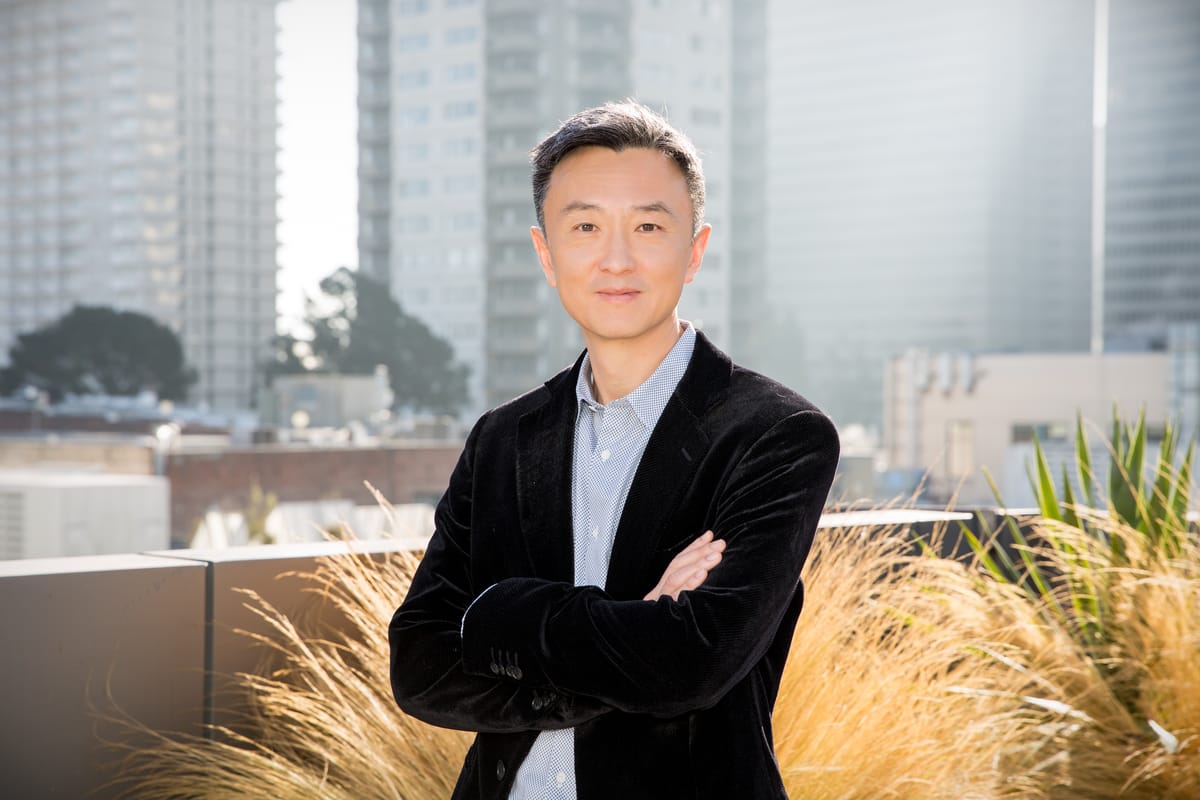 Zuora CEO TienTzuo with multiple grey highrises in the background