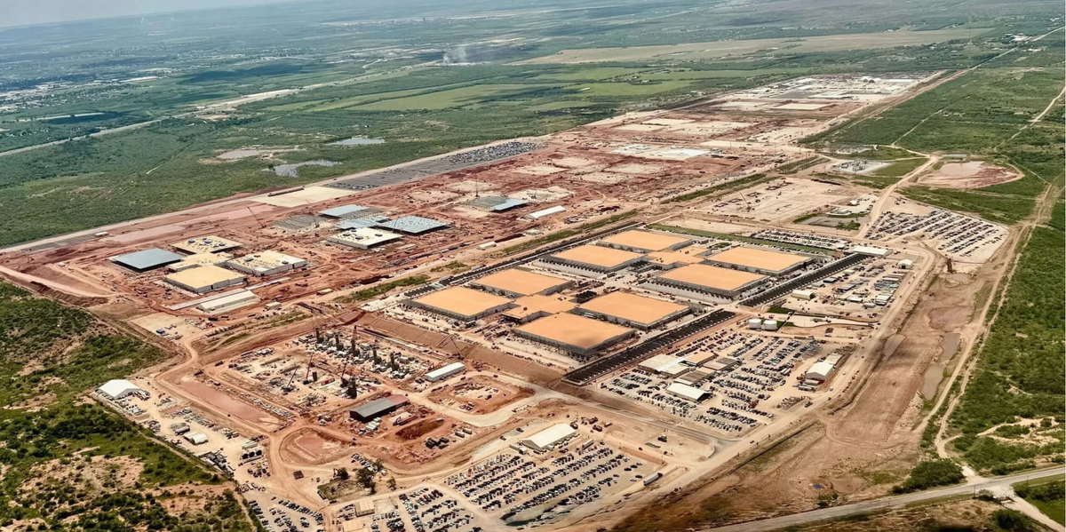 Aerial view of a massive data center campus under construction in a rural landscape.