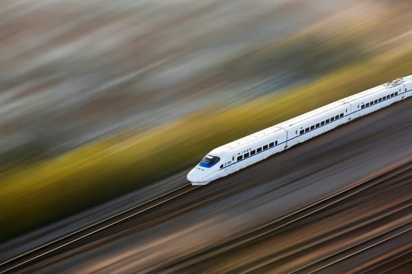 Blurred high speed train racing along the tracks.