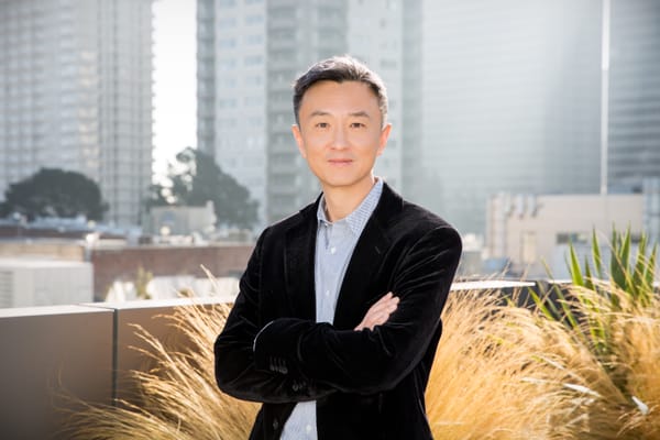 Zuora CEO TienTzuo with multiple grey highrises in the background